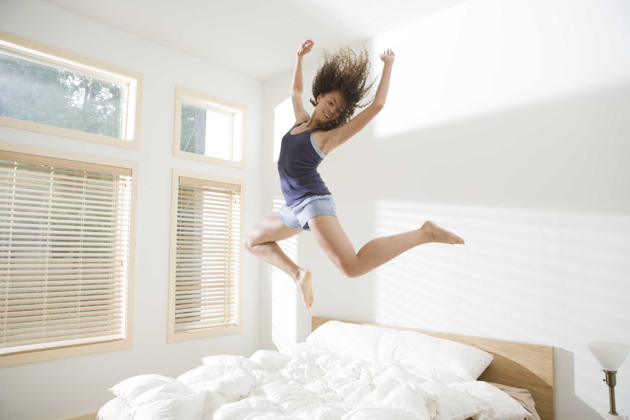 Девушка в прыжке. Девушка прыгает. Девушка прыгает на кровати. Бодрость утром. Сон потом в доме